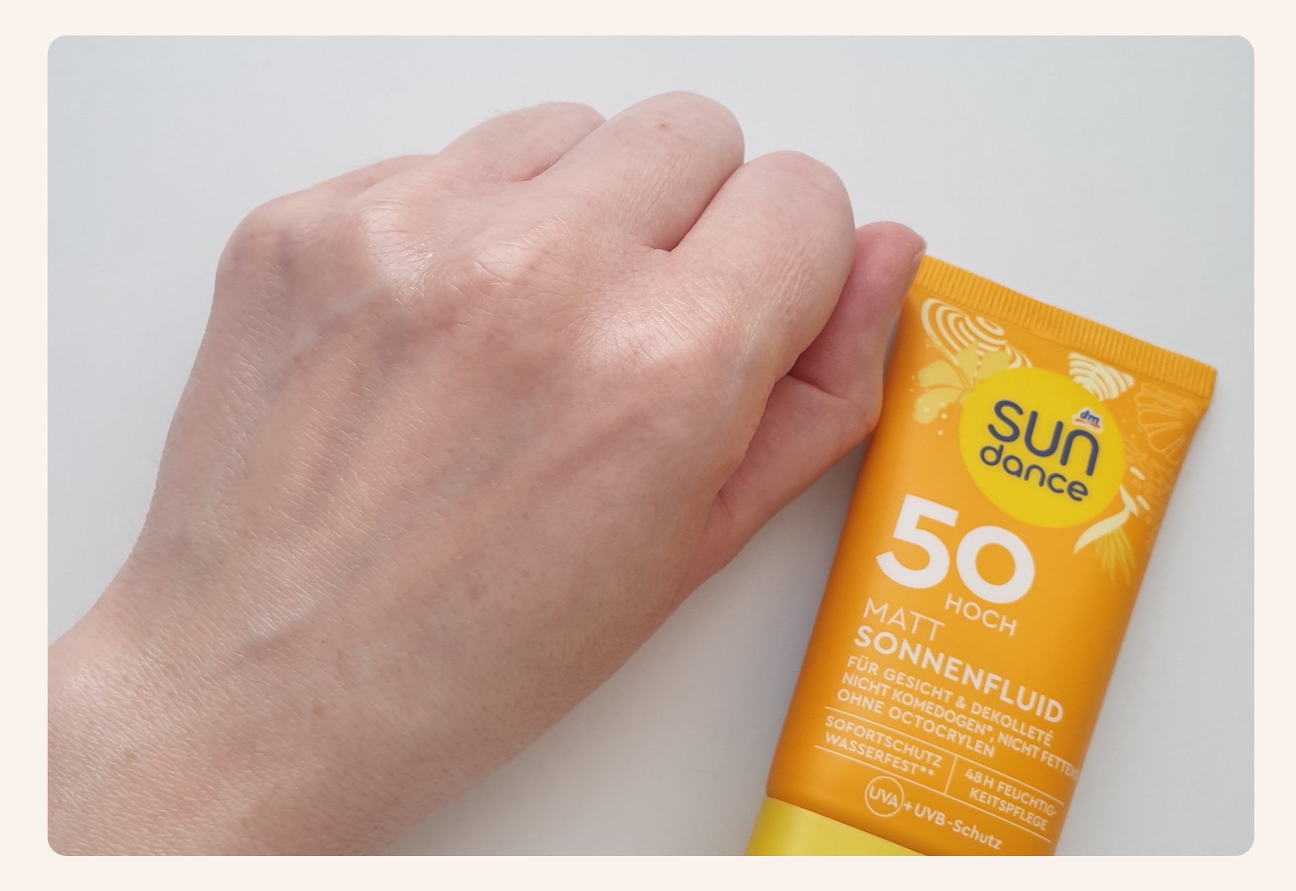Application de la crème solaire SUNdance 50 SPF sur la main, montrant son effet transparent
